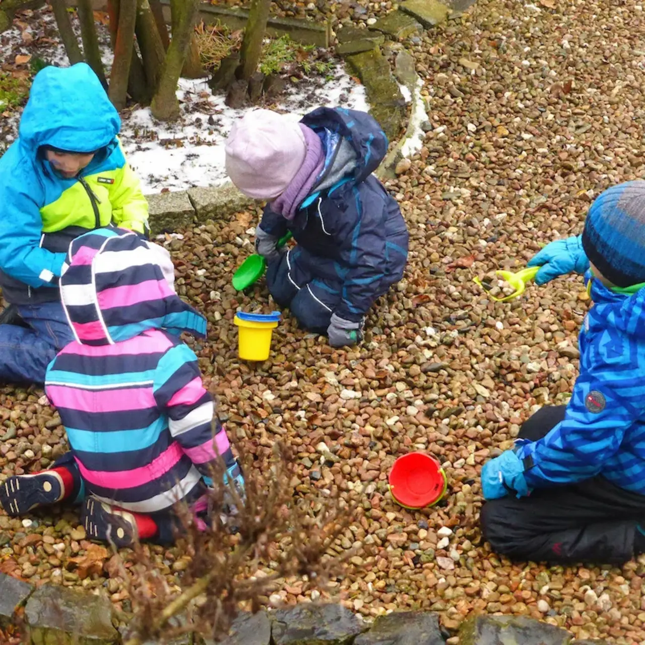 Kinder spielen mit Eimern und Schaufeln